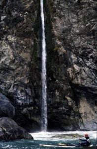 Sea kayaker explores a waterfall tumbling into the Pacific Ocean along the Big Sur coast.