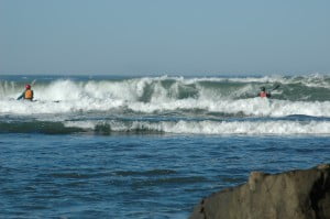 Neil and Tsunami Ranger John Lull (black helmet) punch through incoming waves at the slot.